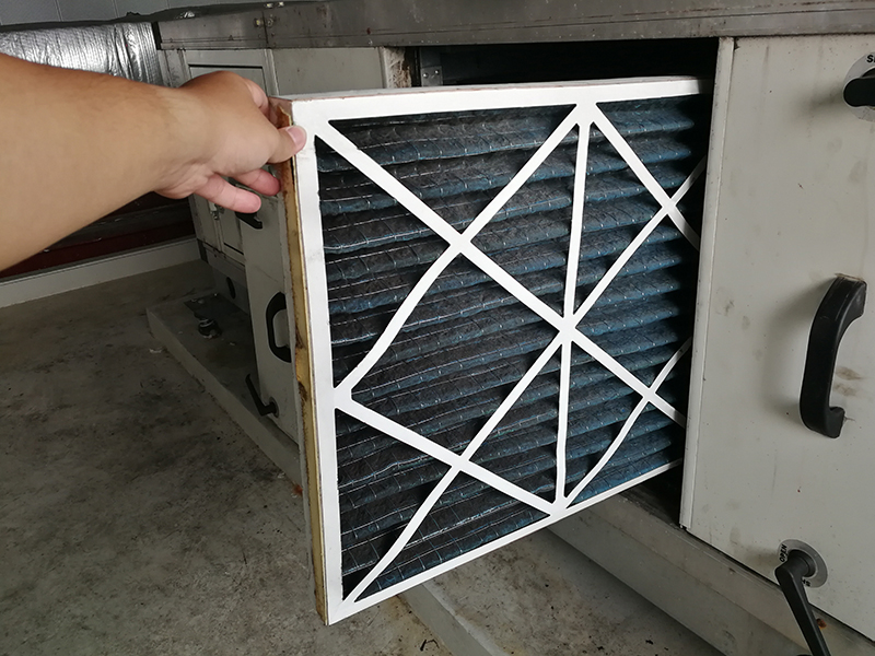 Hand replacing HVAC air filter