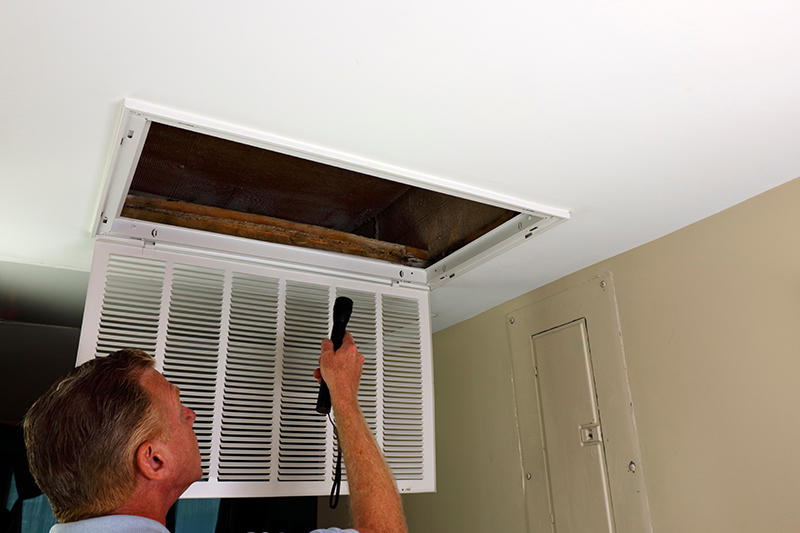 Technician inspecting HVAC vent