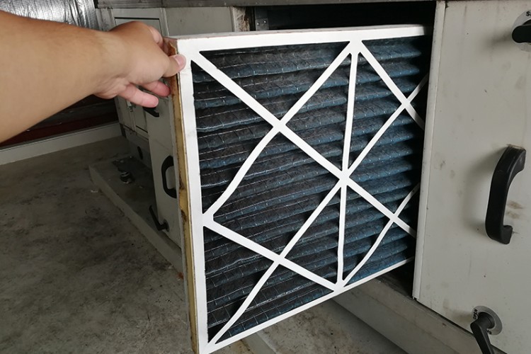 Hand replacing HVAC air filter