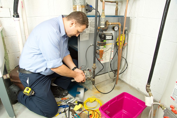 HVAC technician repairing a furnace.