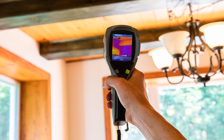 Person's arm holding up an IR indoor air quality test.