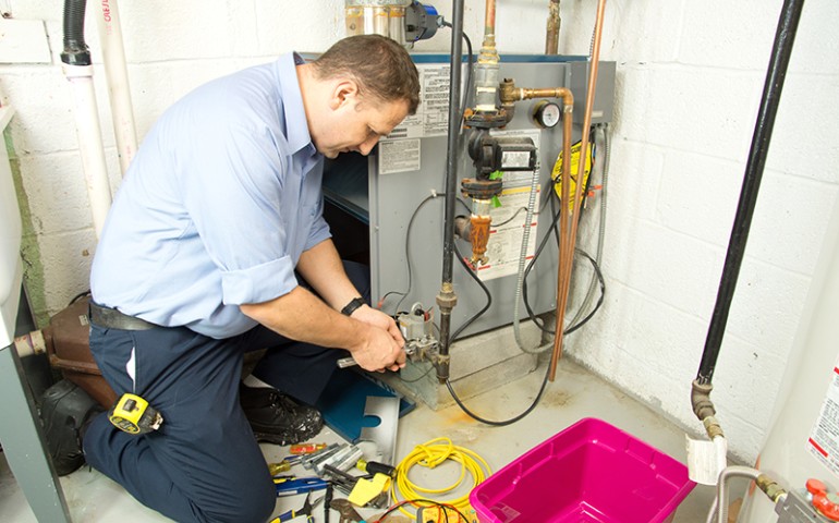 HVAC technician repairing a furnace.