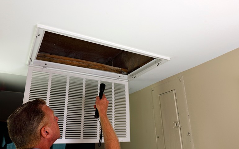 Technician inspecting HVAC vent