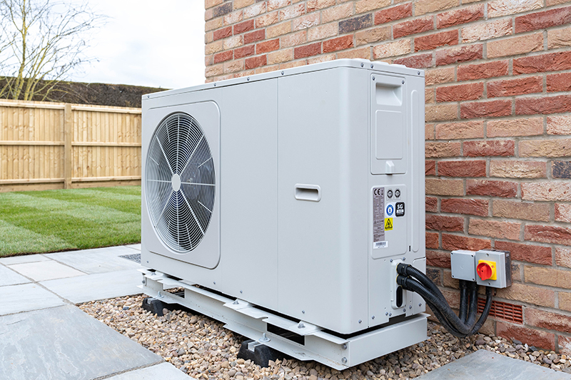 Heat pump outside of a brick wall